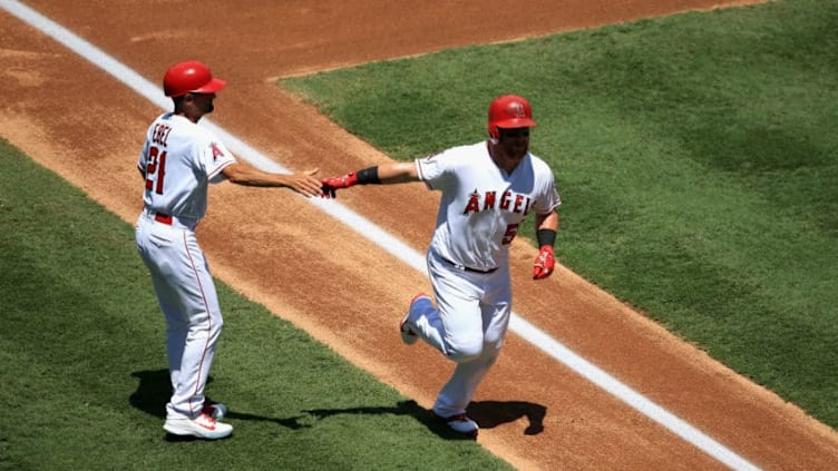 ANAHEIM, CA - AUGUST 08: Kole Calhoun #56 is congratulated by Dino Ebel #21 of the Los Angeles Angels of Anaheim at third base after hitting a solo homerun during the first inning of a game at Angel Stadium on August 8, 2018 in Anaheim, California. (Photo by Sean M. Haffey/Getty Images)