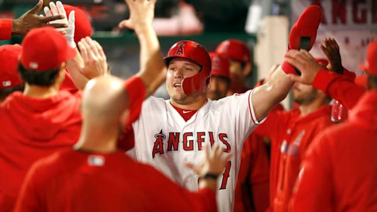 ANAHEIM, CALIFORNIA - APRIL 09: Mike Trout #27 is congratulated in the dugout after scoring on a Albert Pujols #5 of the Los Angeles Angels of Anaheim RBI single during the first inning of a game against the Milwaukee Brewers at Angel Stadium of Anaheim on April 09, 2019 in Anaheim, California. (Photo by Sean M. Haffey/Getty Images)