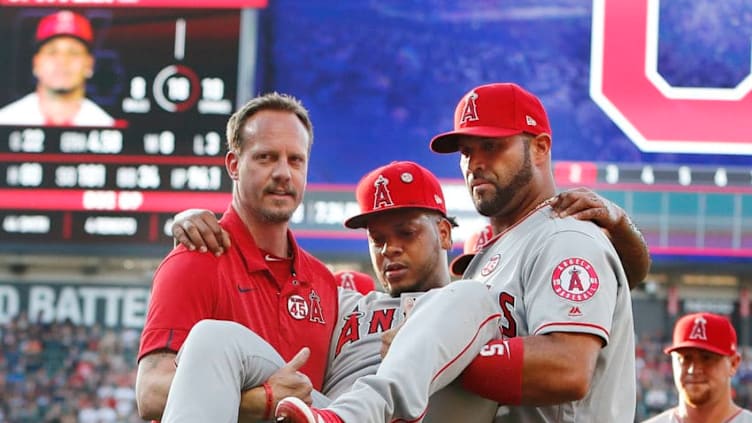 CLEVELAND, OH - AUGUST 03: Albert Pujols #5 helps carry Felix Pena #64 of the Los Angeles Angels of Anaheim off the field after he was injured covering first base to retire Jose Ramirez of the Cleveland Indians in the second inning at Progressive Field on August 3, 2019 in Cleveland, Ohio. (Photo by David Maxwell/Getty Images)