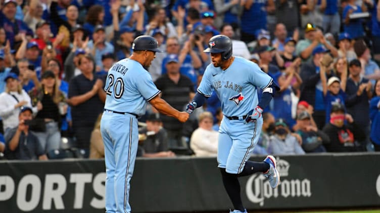 SEATTLE, WASHINGTON - JULY 09: George Springer #4 of the Toronto Blue Jays shakes hands with third base coach Luis Rivera #20 after hitting a solo home run to center field during the sixth inning against the Seattle Mariners at T-Mobile Park on July 09, 2022 in Seattle, Washington. (Photo by Alika Jenner/Getty Images)