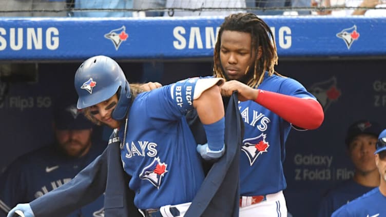 Oct 2, 2021; Toronto, Ontario, CAN; Toronto Blue Jays shortstop Bo Bichette (11) is helped into the team home run jacket by first baseman Vladimir Guererro Jr. (27) after hitting a solo home run in the fifth inning at Rogers Centre. Mandatory Credit: Dan Hamilton-USA TODAY Sports