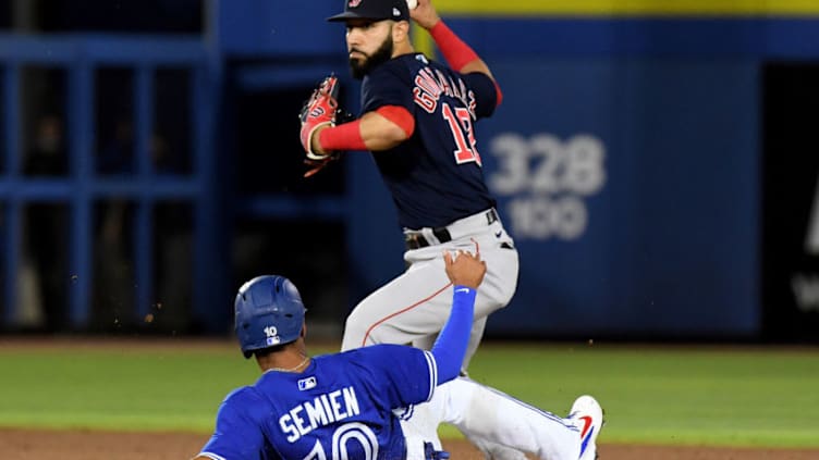 May 19, 2021; Dunedin, Florida, CAN; Boston Red Sox infielder Marwin Gonzalez (12) prepares to throw to first base as Toronto Blue Jays infielder Marcus Semien (10) slides in the fifth inning at TD Ballpark. Mandatory Credit: Jonathan Dyer-USA TODAY Sports