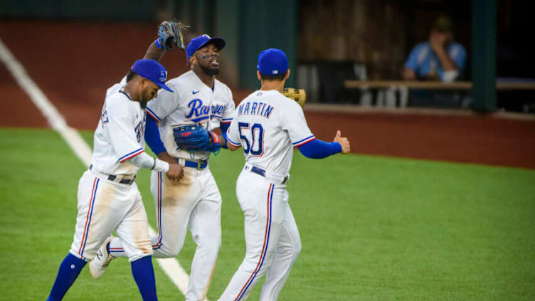 Aug 19, 2021; Arlington, Texas Rangers second baseman Yonny Hernandez (65) and right fielder Adolis Garcia (53) and left fielder Jason Martin (50) celebrate a catch by Garcia on a ball hit by Seattle Mariners center fielder Jake Fraley (not pictured) during the eleventh inning at Globe Life Field. Mandatory Credit: Jerome Miron-USA TODAY Sports