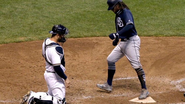 MILWAUKEE, WI - AUGUST 09: Freddy Galvis #13 of the San Diego Padres crosses home plate past Manny Pina #9 of the Milwaukee Brewers after hitting a home run in the sixth inning at Miller Park on August 9, 2018 in Milwaukee, Wisconsin. (Photo by Dylan Buell/Getty Images)