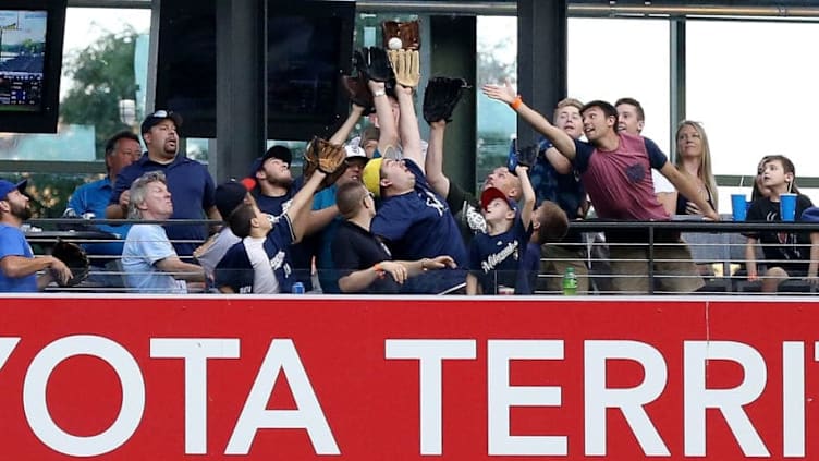 MILWAUKEE, WI - AUGUST 08: Fans attempt to catch a home run hit by Eric Thames #7 of the Milwaukee Brewers in the first inning against the San Diego Padres at Miller Park on August 8, 2018 in Milwaukee, Wisconsin. (Photo by Dylan Buell/Getty Images)