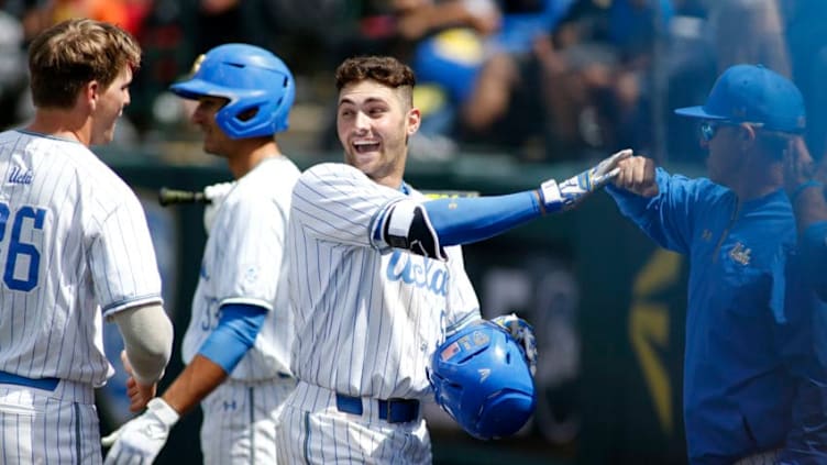 LOS ANGELES, CALIFORNIA - MAY 19: Garrett Mitchell #5 of UCLA fist-bumps a coach as he makes his way to the dugout following his home run during a baseball game against University of Washington at Jackie Robinson Stadium on May 19, 2019 in Los Angeles, California. (Photo by Katharine Lotze/Getty Images)