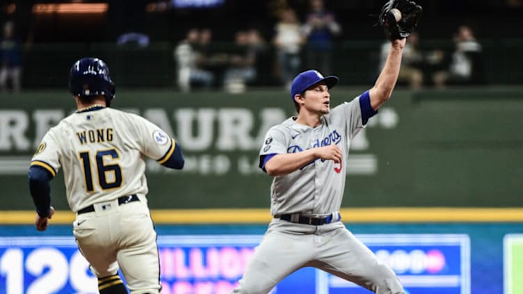 Apr 29, 2021; Milwaukee, Wisconsin, USA; Los Angeles Dodgers shortstop Corey Seager (5) forces out Milwaukee Brewers second baseman Kolten Wong (16) in the sixth inning at American Family Field. Mandatory Credit: Benny Sieu-USA TODAY Sports