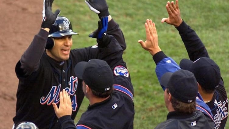 New York Mets Robin Ventura is congratulated by his teammates after his two-run home run in the first inning against the San Francisco Giants during the National League Division Series 08 October, 2000 at Shea Stadium in New York. AFP PHOTO Doug KANTER (Photo by MATT CAMPBELL / AFP) (Photo credit should read MATT CAMPBELL/AFP via Getty Images)