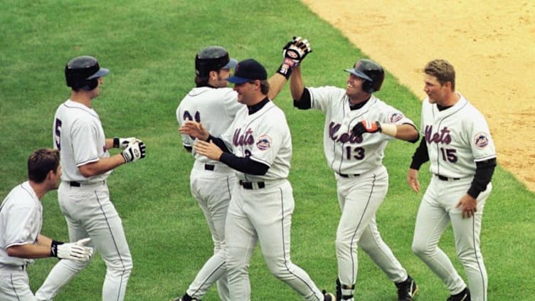 New York Mets' Edgardo Alfonzo (13) is congratulated by teammates after batting in the winning run in the ninth inning of game against the St. Louis Cardinals 22 August, 1999, at Shea Stadium in New York. The Mets scored two runs in the bottom of the ninth to win the first game of a doubleheader, 8-7. Matt Franco (15) scored the winning run. AFP PHOTO Stan HONDA (Photo by STAN HONDA / AFP) (Photo by STAN HONDA/AFP via Getty Images)