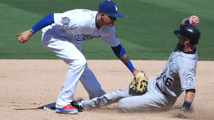 LOS ANGELES, CA - OCTOBER 01: David Dahl #26 of the Colorado Rockies is tagged out at second by Manny Machado #8 of the Los Angeles Dodgers after he is caught stealing in the fourth inning of the game at Dodger Stadium on October 1, 2018 in Los Angeles, California. (Photo by Jayne Kamin-Oncea/Getty Images)