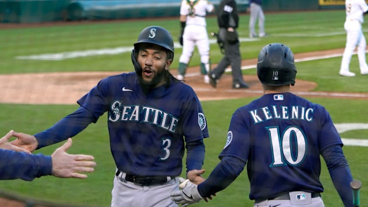 OAKLAND, CALIFORNIA - MAY 25: J.P. Crawford #3 of the Seattle Mariners is congratulated by Jarred Kelenic #10 after scoring against the Oakland Athletics. (Photo by Thearon W. Henderson/Getty Images)