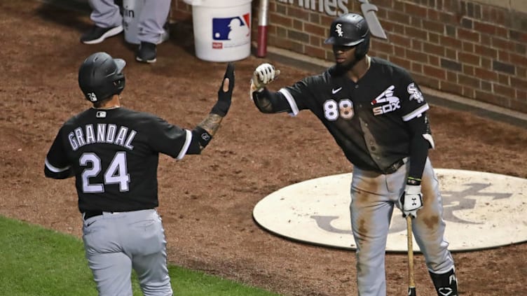 CHICAGO, ILLINOIS - JULY 19: Yasmani Grandal #24 of the Chicago White Sox is congratulated by Luis Robert #88 after scoring in the 5th inning against the Chicago Cubs during an exhibition game at Wrigley Field on July 19, 2020 in Chicago, Illinois. (Photo by Jonathan Daniel/Getty Images)