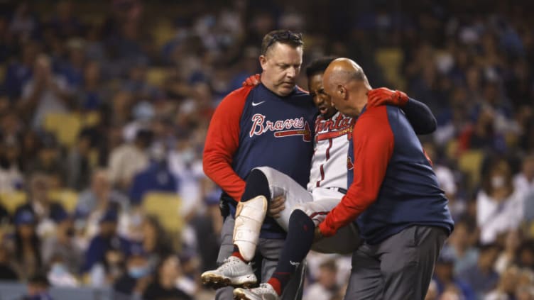 LOS ANGELES, CALIFORNIA - AUGUST 31: Ozzie Albies #1 of the Atlanta Braves reacts to an apparent injury while being carried off the field during a game against the Los Angeles Dodgers the fifth inning at Dodger Stadium on August 31, 2021 in Los Angeles, California. (Photo by Michael Owens/Getty Images)
