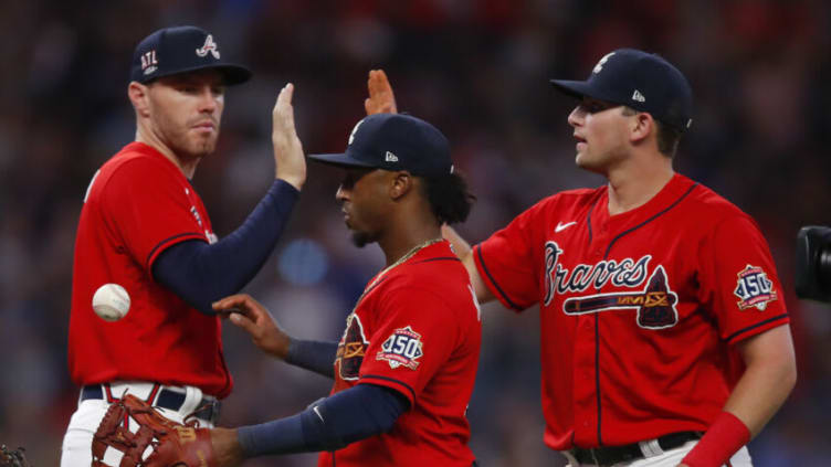 ATLANTA, GA - JULY 02: Ozzie Albies #1 of the Atlanta Braves celebrates the victory with Freddie Freeman #5 and Austin Riley #27 at the conclusion of an MLB game against the Miami Marlins at Truist Park on July 2, 2021 in Atlanta, Georgia. (Photo by Todd Kirkland/Getty Images)