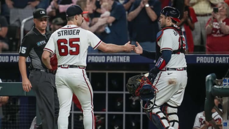 Sep 1, 2022; Cumberland, Georgia, USA; Atlanta Braves starting pitcher Spencer Strider (65) reacts with catcher Travis d'Arnaud (16) after recording his sixteenth strikeout against the Colorado Rockies during the eighth inning at Truist Park. Mandatory Credit: Dale Zanine-USA TODAY Sports