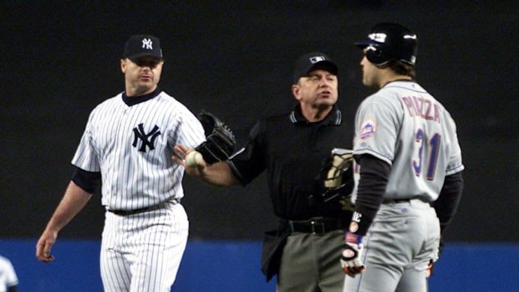 Home plate umpire Charlie Reliford (C) comes between New York Yankees' pitcher Roger Clemens (L) and New York Mets' catcher Mike Piazza after Clemens threw Piazza's broken bat at Piazza as he ran to first base during the first inning of the Second Game of the World Series in New York City 22 October 2000. AFP PHOTO/Gary HIRSHORN/POOL (Photo by GARY HIRSHORN / POOL / AFP) (Photo credit should read GARY HIRSHORN/AFP via Getty Images)