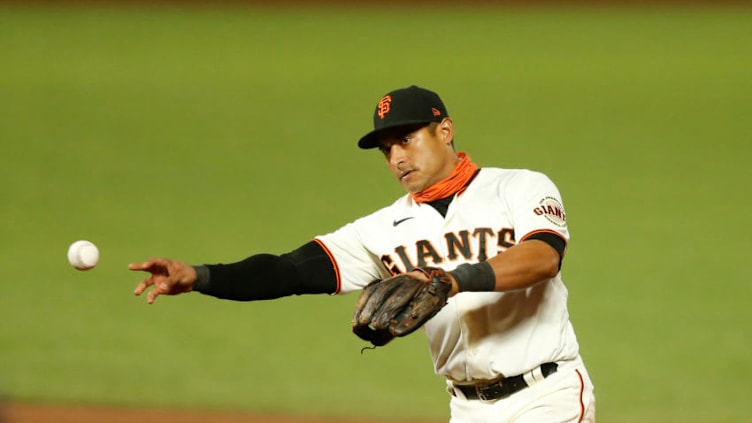 SAN FRANCISCO, CALIFORNIA - SEPTEMBER 22: Donovan Solano #7 of the San Francisco Giants fields the ball against the Colorado Rockies at Oracle Park on September 22, 2020 in San Francisco, California. (Photo by Lachlan Cunningham/Getty Images)