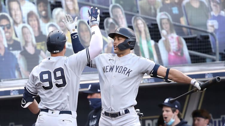 SAN DIEGO, CALIFORNIA - OCTOBER 09: Aaron Judge #99 of the New York Yankees is congratulated by Giancarlo Stanton #27 after hitting a solo home run against the Tampa Bay Rays during the fourth inning in Game Five of the American League Division Series at PETCO Park on October 09, 2020 in San Diego, California. (Photo by Sean M. Haffey/Getty Images)