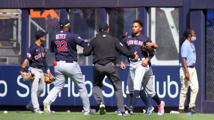 NEW YORK, NEW YORK - APRIL 23: Oscar Mercado #35 of the Cleveland Guardians is restrained as fans throw debris on the field following Gleyber Torres #25 of the New York Yankees walk off RBI single in the bottom of the ninth inning at Yankee Stadium on April 23, 2022 in New York City. (Photo by Mike Stobe/Getty Images)