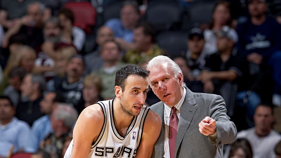 Manu Ginobili and Gregg Popovich talk on the sideline during a Spurs game.