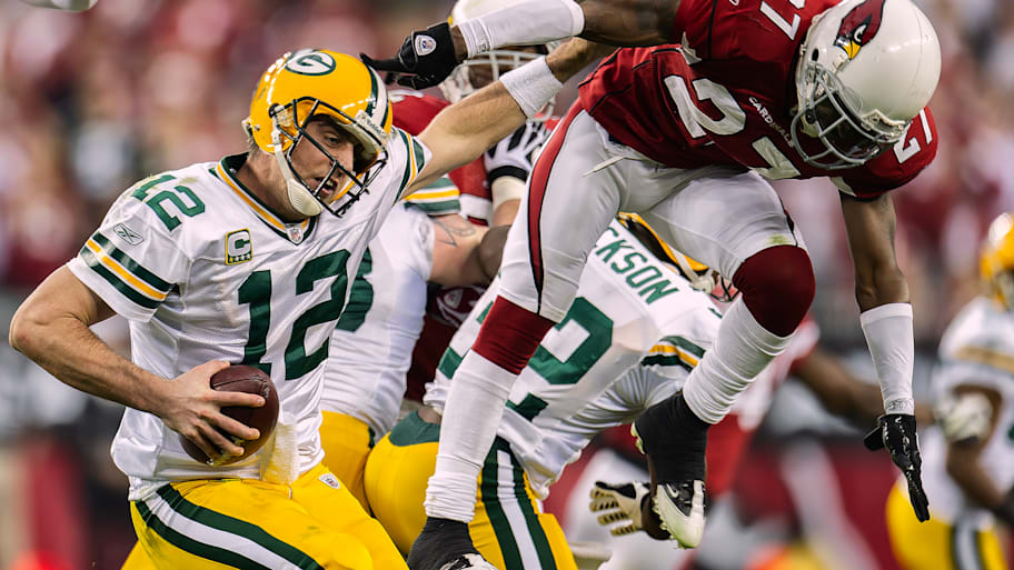 Aaron Rodgers fends off a Cardinals tackler in a playoff game