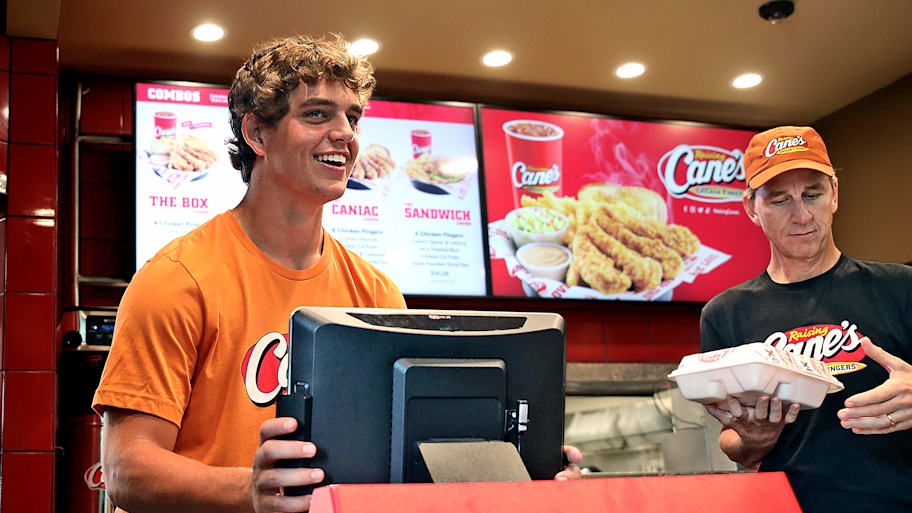 Arch and Cooper Manning work the register at Raising Cane’s.