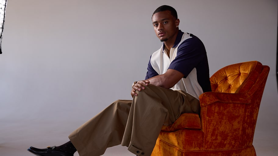 Patrick Surtain II poses seated in an orange chair