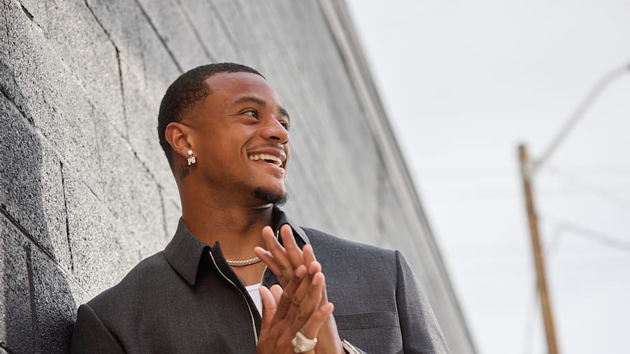 Pat Surtain II poses with his hands together against a black wall