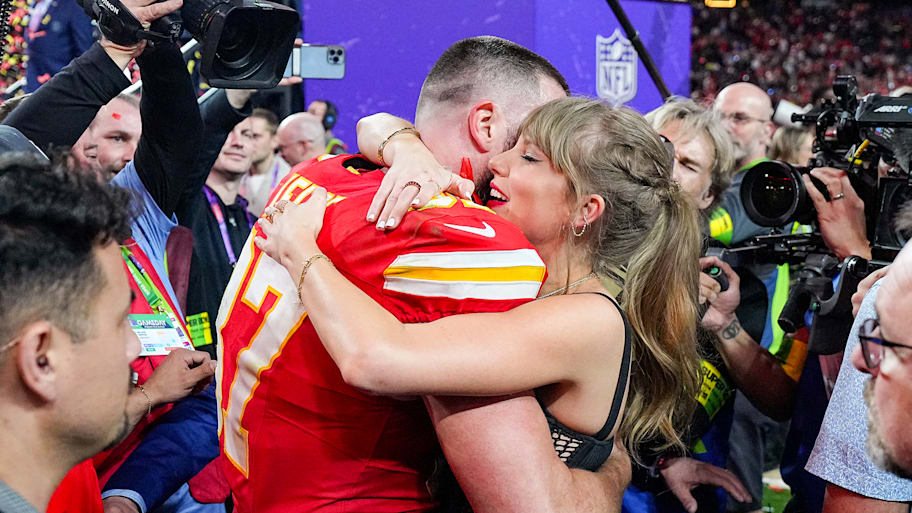 Travis Kelce (87) hugs girlfriend and singer Taylor Swift