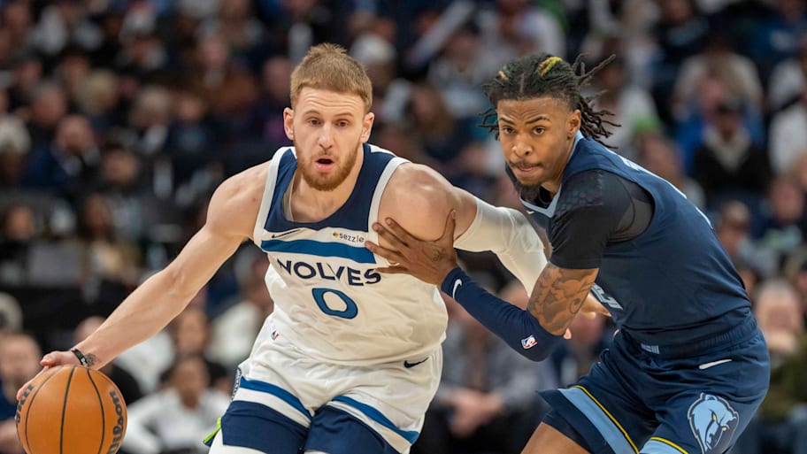 Minnesota Timberwolves shooting guard Donte DiVincenzo dribbles the ball against Memphis Grizzlies guard Ja Morant.