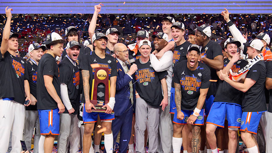 Florida men's basketball coach Todd Golden and his players celebrate winning the title on stage.