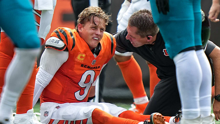 Joe Burrow on the ground being looked at by trainers.
