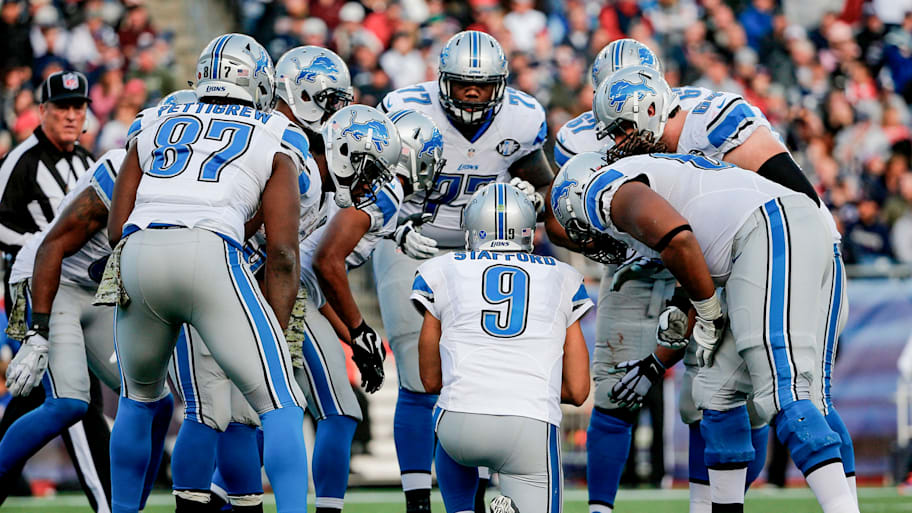 Matthew Stafford kneels in the huddle for the Lions.