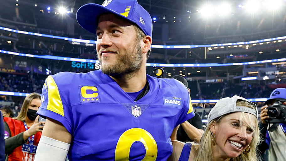 Matthew and Kelly Stafford smile on the field after winning the NFC championship game.