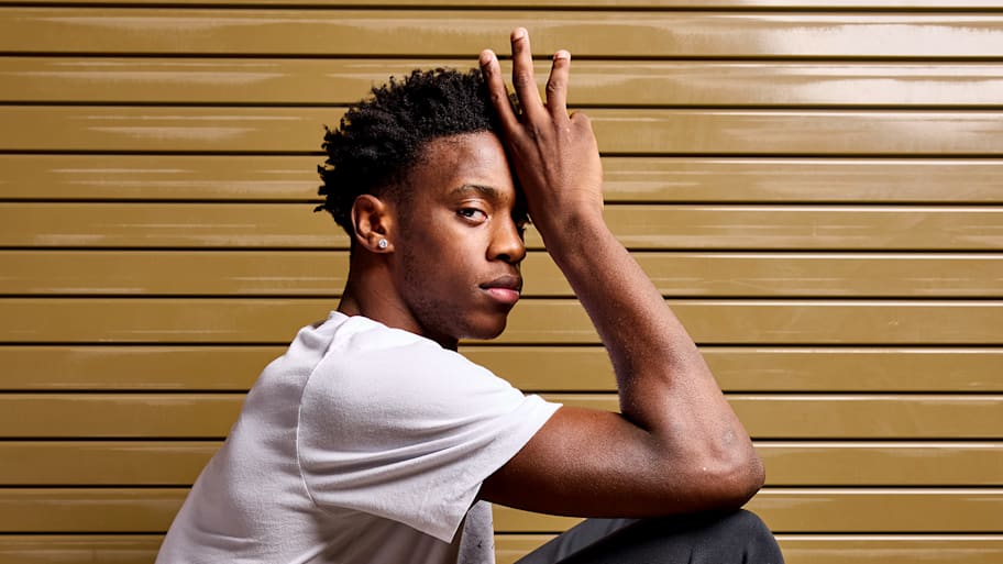 AJ Dybantsa sits on a basketball posing for a photo.
