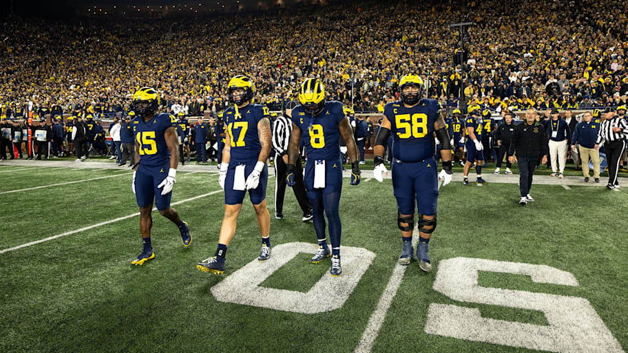 Four Michigan’s captains take the field before a game against Purdue.