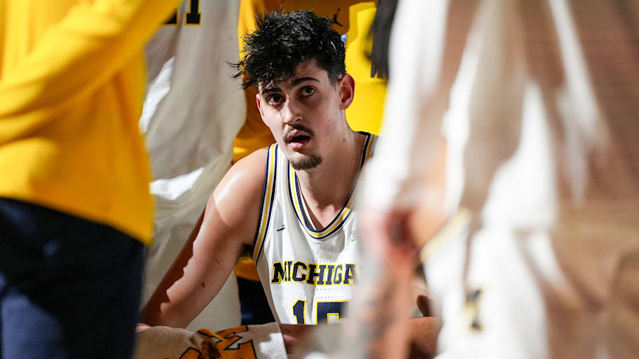 Michigan center Aday Mara sits in a huddle during the title game.