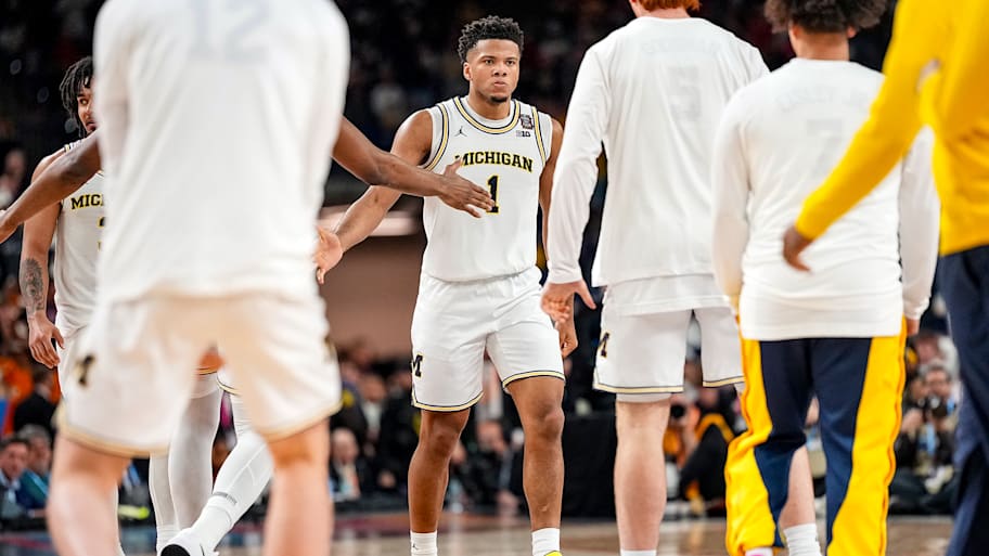 Michigan freshman guard Trey McKenney slaps hands with his teammates during the national title game.