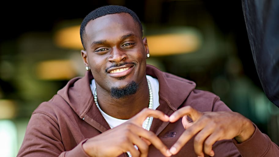 Jeremiyah Love makes his signature heart celebration with his fingers.