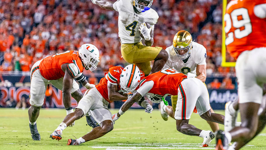 Jeremiyah Love leaps over a Miami defender.