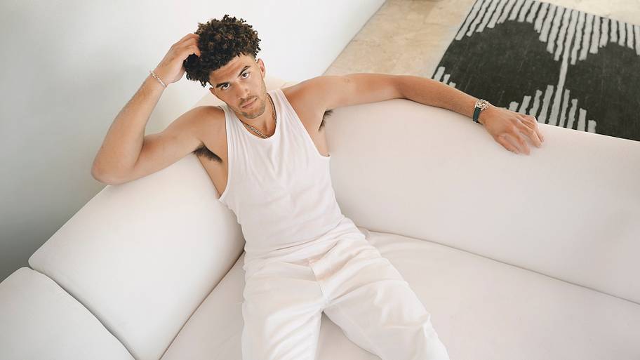 Cameron Boozer sitting on a white couch at home.