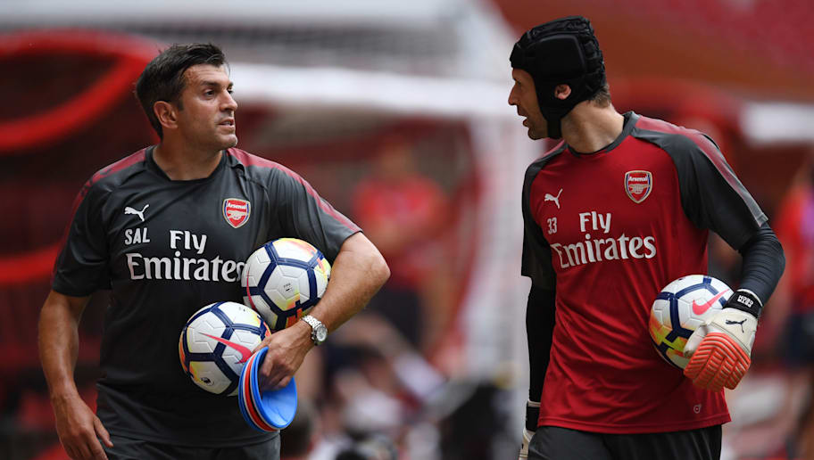 Arsenal goalkeeper Petr Cech (R) walks with a team official during a football training session in Beijing's National Stadium, known as the Bird's Nest, on July 21, 2017. Arsenal will play Chelsea at the Bird's Nest on July 22. / AFP PHOTO / GREG BAKER (Photo credit should read GREG BAKER/AFP/Getty Images)