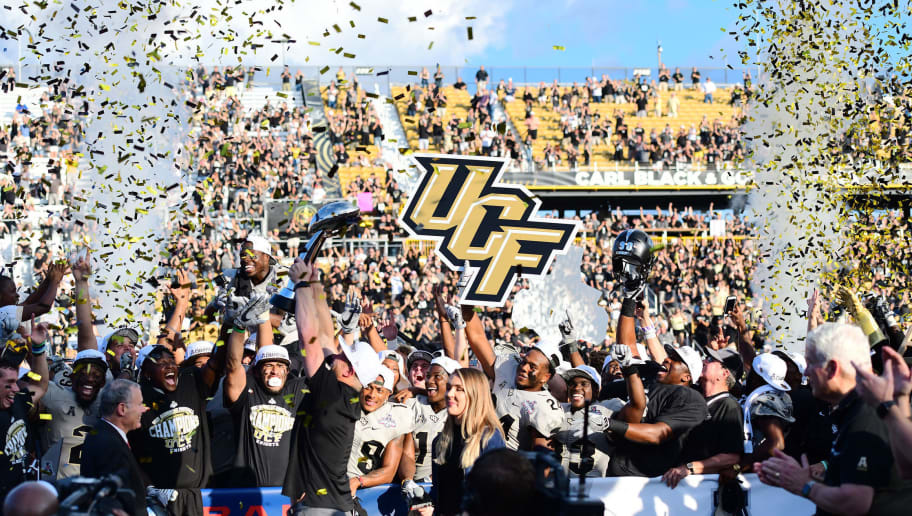 ORLANDO, FL - DECEMBER 2:  Head coach Scott Frost of the UCF Knights hoists the American Athletics Conference Trophy after winning the ACC Championship 62-55 against the Memphis Tigers at Spectrum Stadium on December 2, 2017 in Orlando, Florida. (Photo by Julio Aguilar/Getty Images)