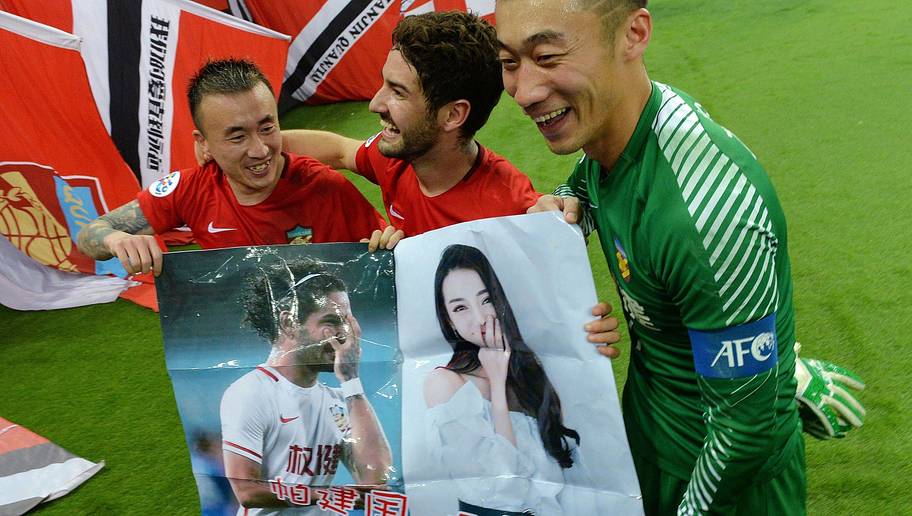 This picture taken on March 14, 2018 shows Alexandre Pato of Tianjin Quanjian (C) holding a poster, showing pictures of him and Chinese actress Dilraba Dilmurat, with teammates Wang Yongpo (L) and Zhang Lu after the AFC Champions League group stage football match between China's Tianjin Quanjian and South Korea's Jeonbuk Hyundai in Tianjin. The poster reads, 'Pa Jianguo, play well, Dilraba is watching the live broadcast.' Brazilian football star Alexandre Pato celebrated Tianjin Quanjian's victory in the AFC Champions League with a very public attempt at wooing the Chinese actress Dilraba Dilmurat. / AFP PHOTO / - / China OUT (Photo credit should read -/AFP/Getty Images)