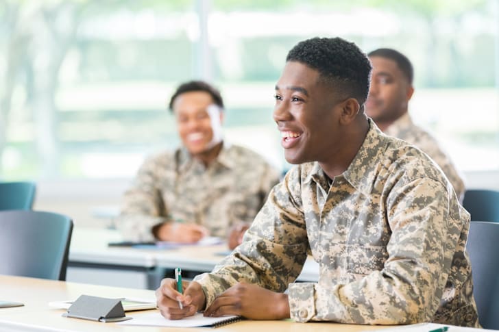 Military member laughing at a desk.