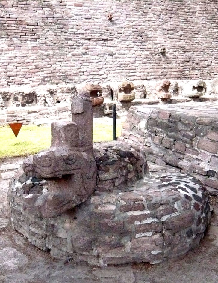 A stone statue of Xiuhcoatl at an Aztec site