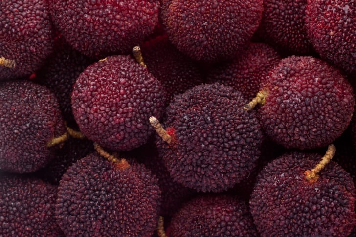 A basket of purple, bumpy-skinned Chinese bayberries.