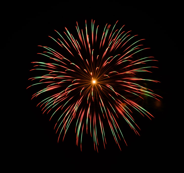 A red and green firework bursting in the night sky