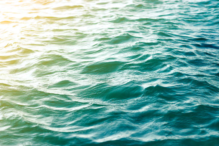 Colorful picture of the sun hitting ocean waves.