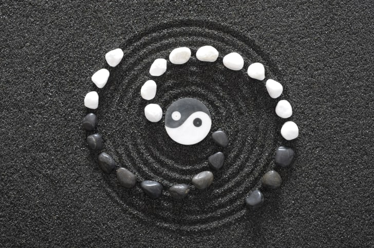 Yin and yang symbol on textured sand.
